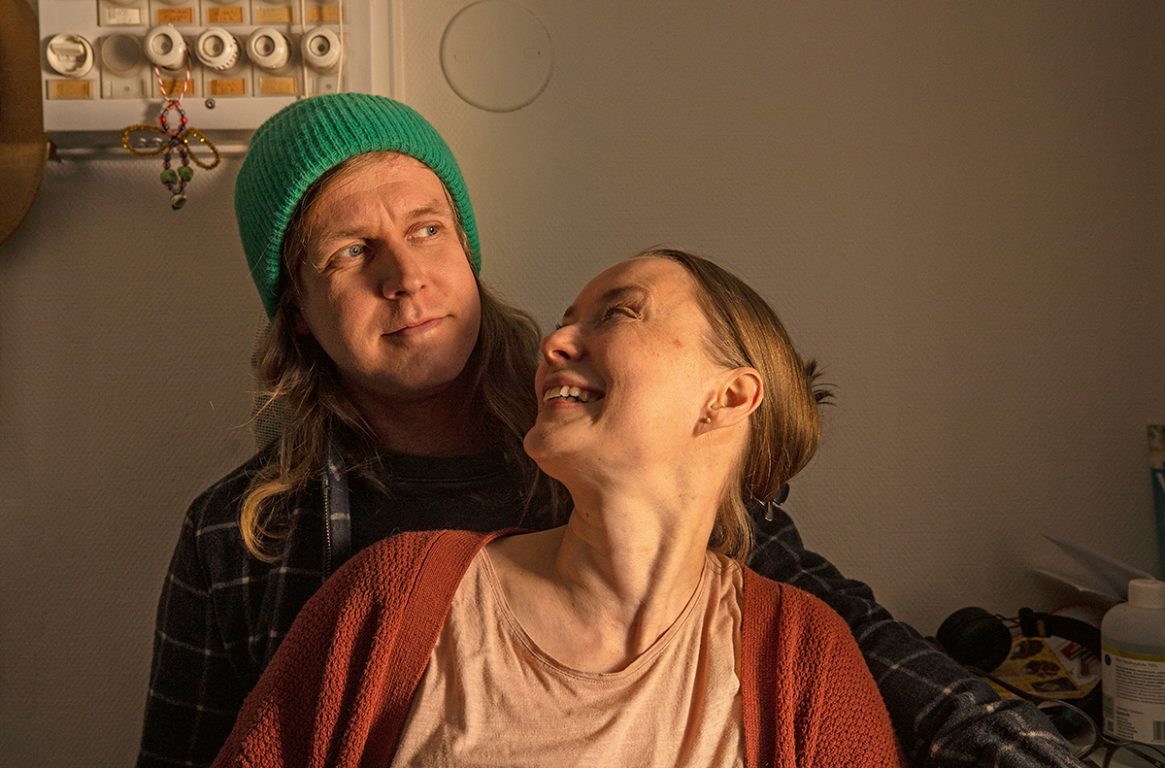 Mikko ja Nea istuvat sylikkäin ja Nea katsoo Mikkoa kohti hymyillen.