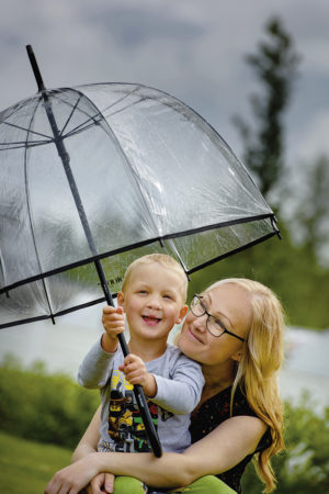 Annika Ammesmäki-Kangasniemi ja Niila nauttivat kesällä harvinaisesta sadekuurosta.