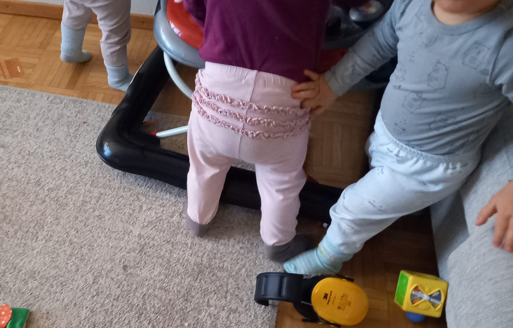 Kolmen lapsen alavartalo, kaikki kävelytuolin kimpussa.