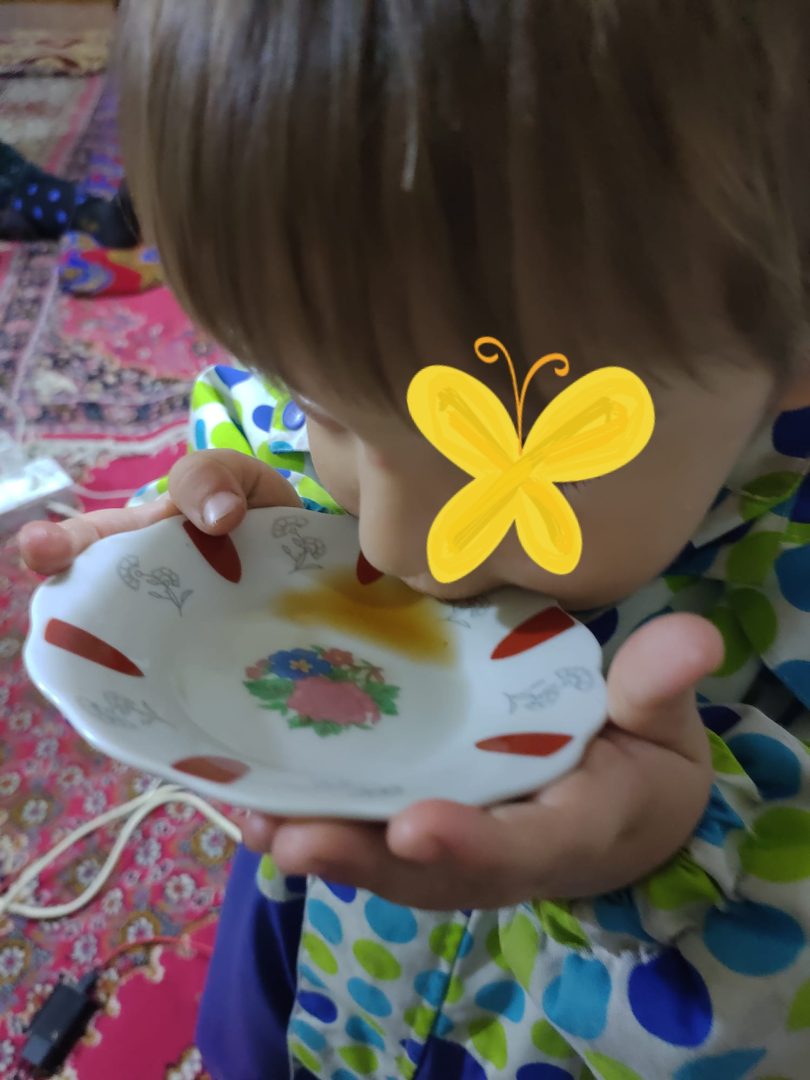 Lapsi ryystämässä teetilkkaa pikkulautaselta.