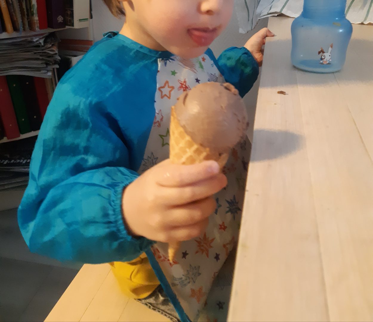 Lapsi jäätelötötterö kädessä.