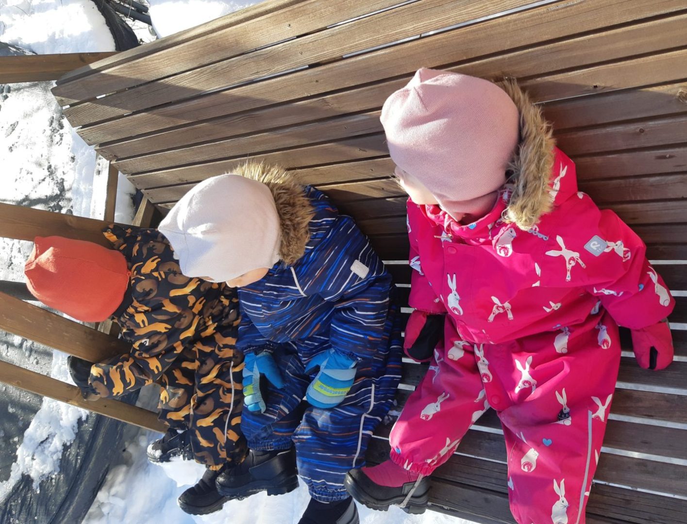 Kolme lasta puutarhakeinussa.