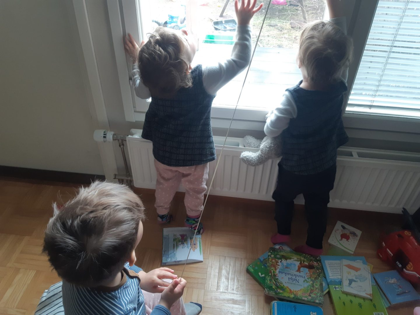 Kolme lasta ikkunan äärellä.