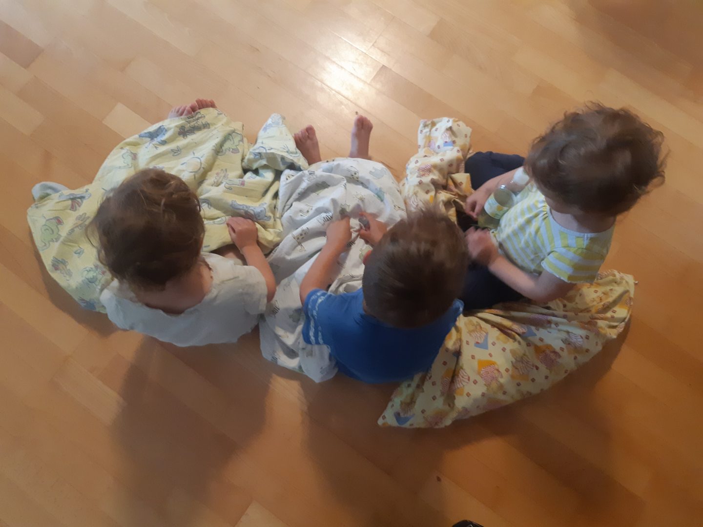 Kolme lasta istumassa lattialla.