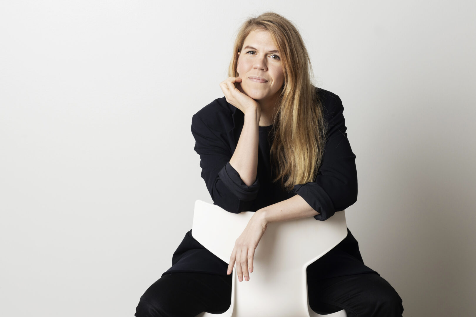 Julia Thuren istuu tuolilla ja katsoo kameraan hymyillen.