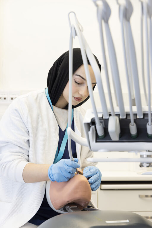 Fatin hoitaa asiakkaansa hampaita työpaikallaan hammashoitolassa.