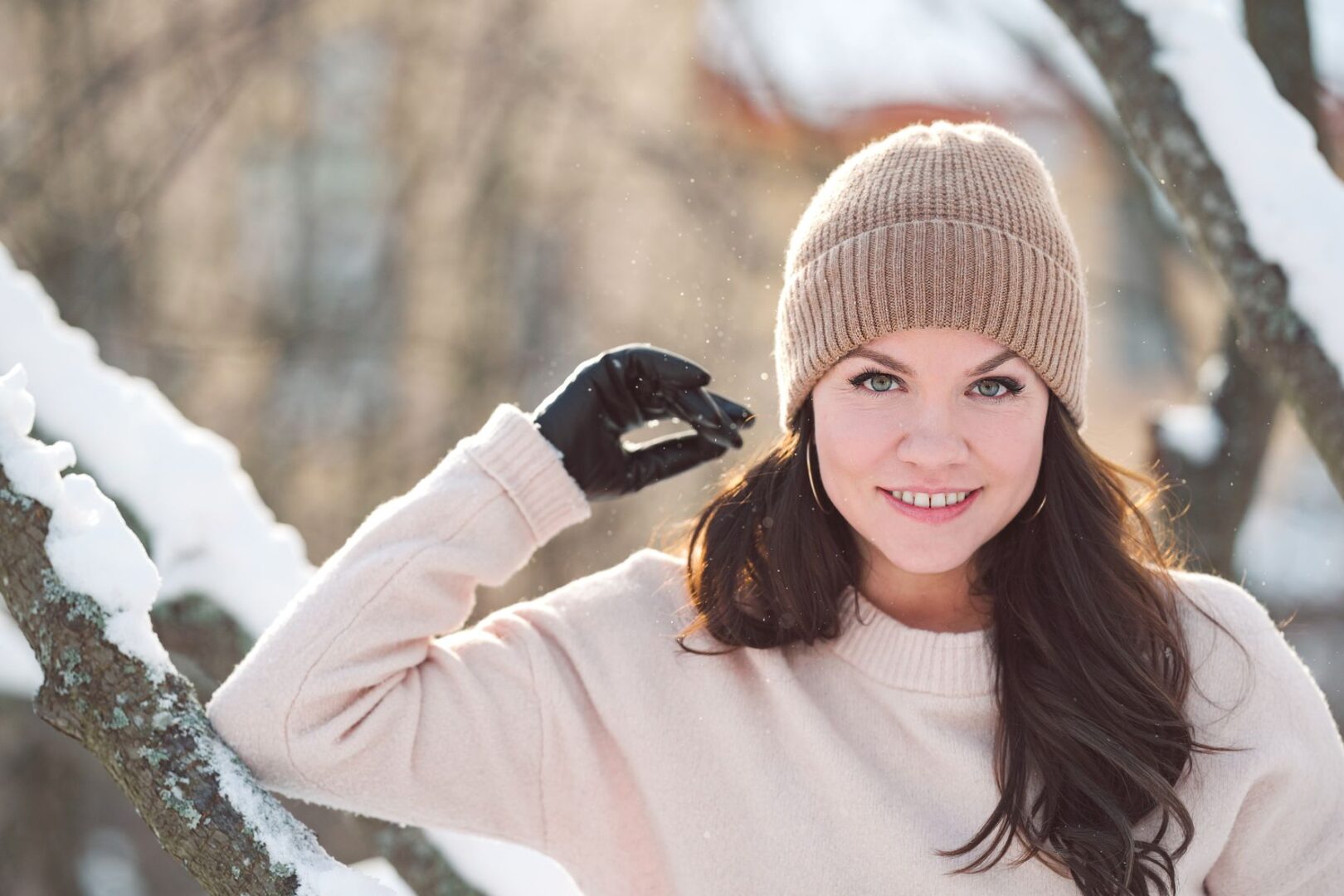 Hannele Lampela pipo päässä ulkona. Taustalla on lumisia puunrunkoja.