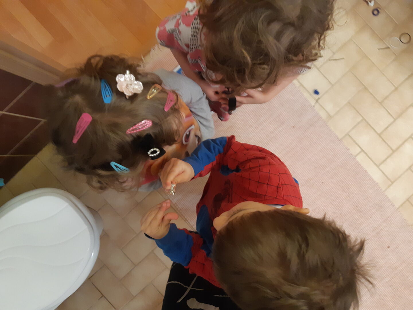 Kolme lasta kylpyhuoneessa.