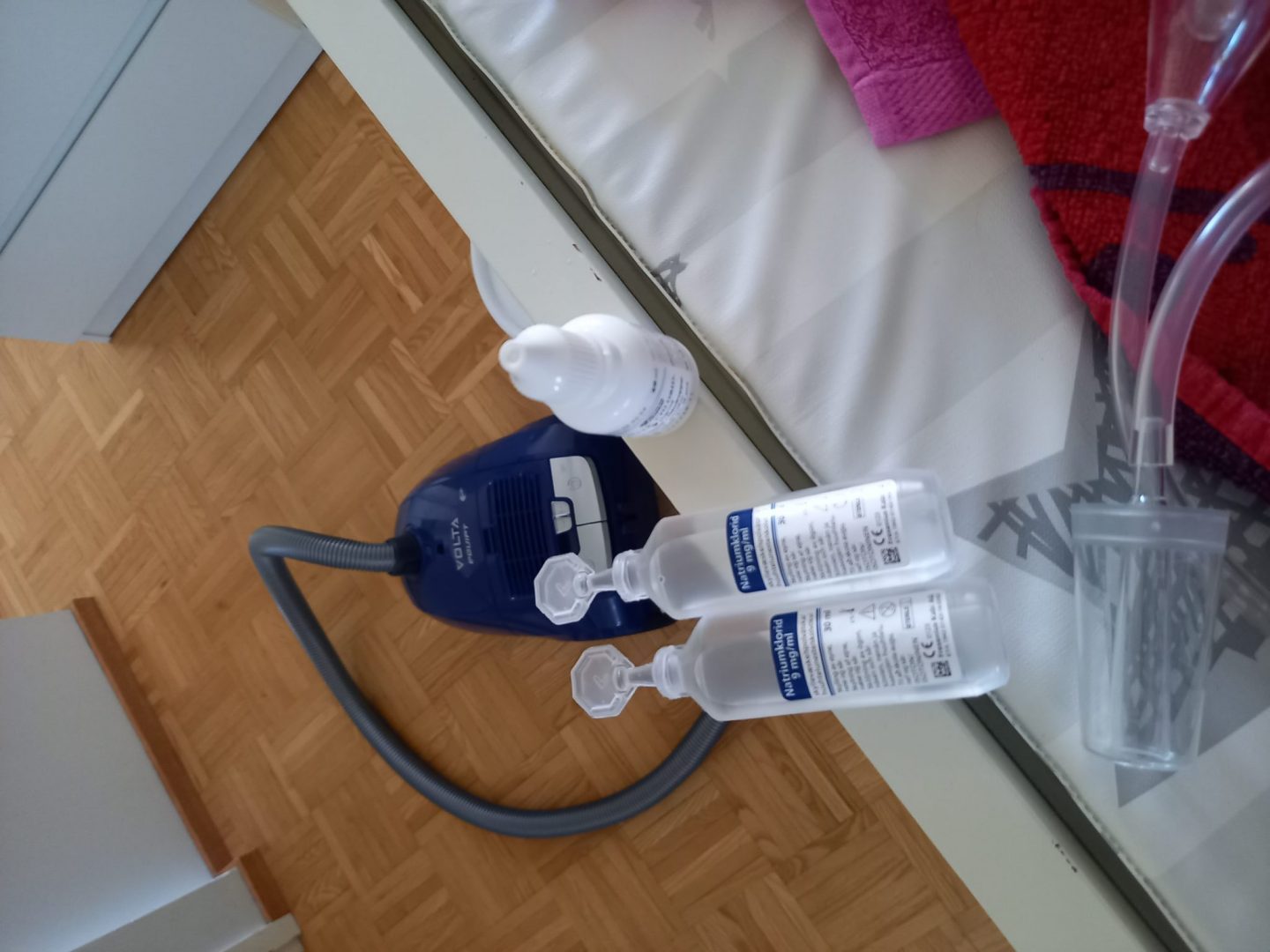 Kuva keittosuolaliuoksista, imurista ja nenäimurista.