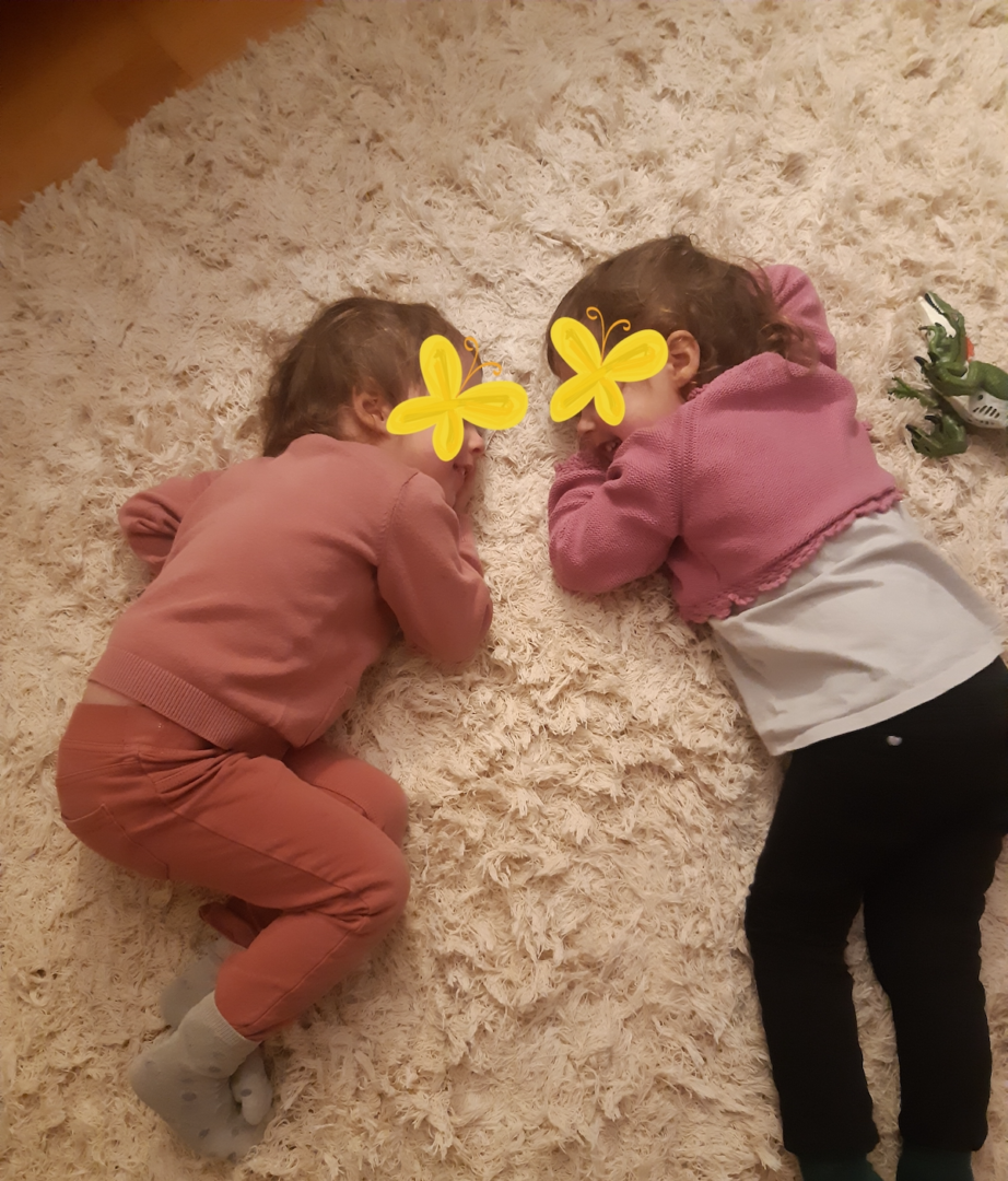 Kaksi lasta makaa matolla vastatusten.