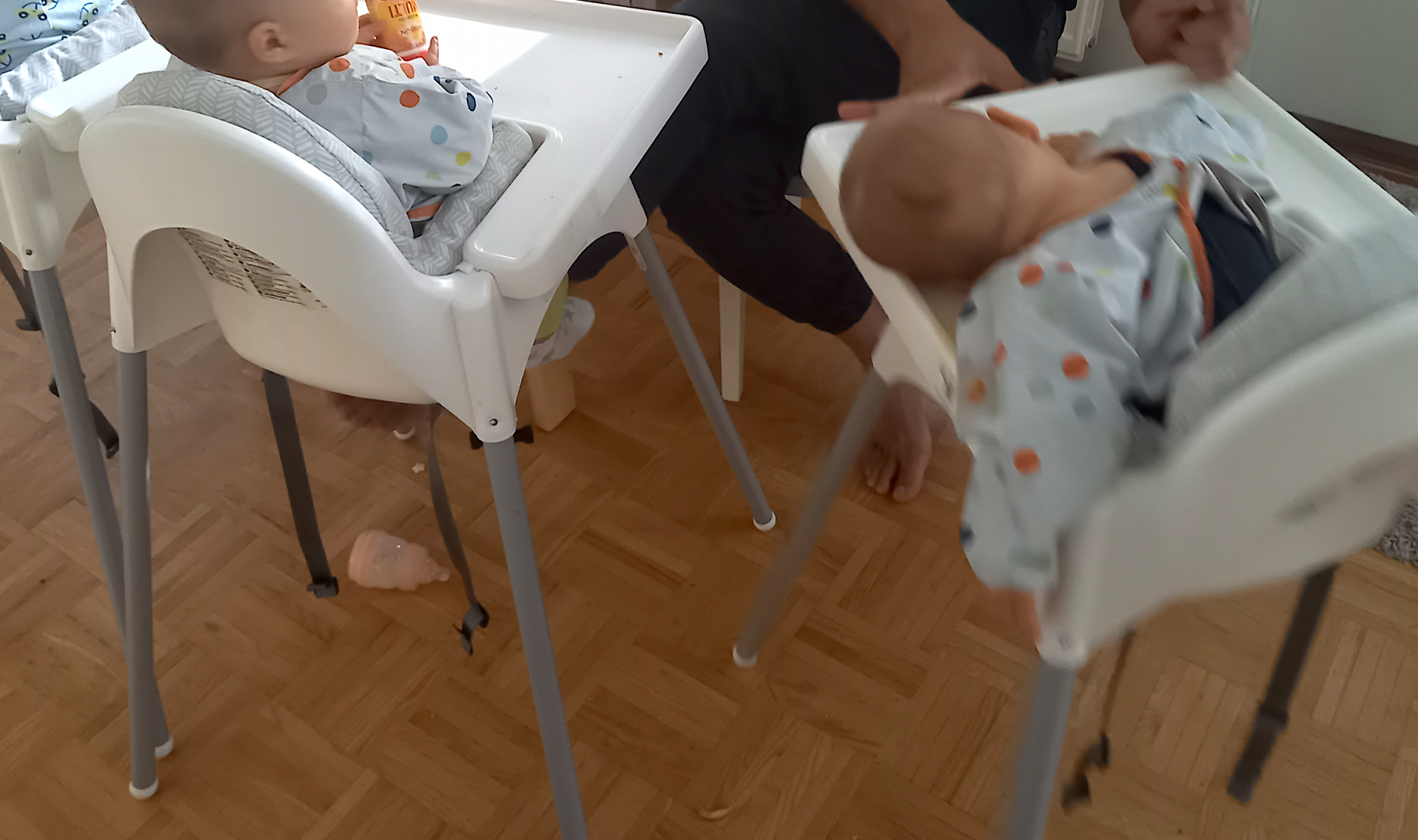 Vauvoja syöttötuoleissa takaapäin, yksi nukahtanut pää pöydällä.