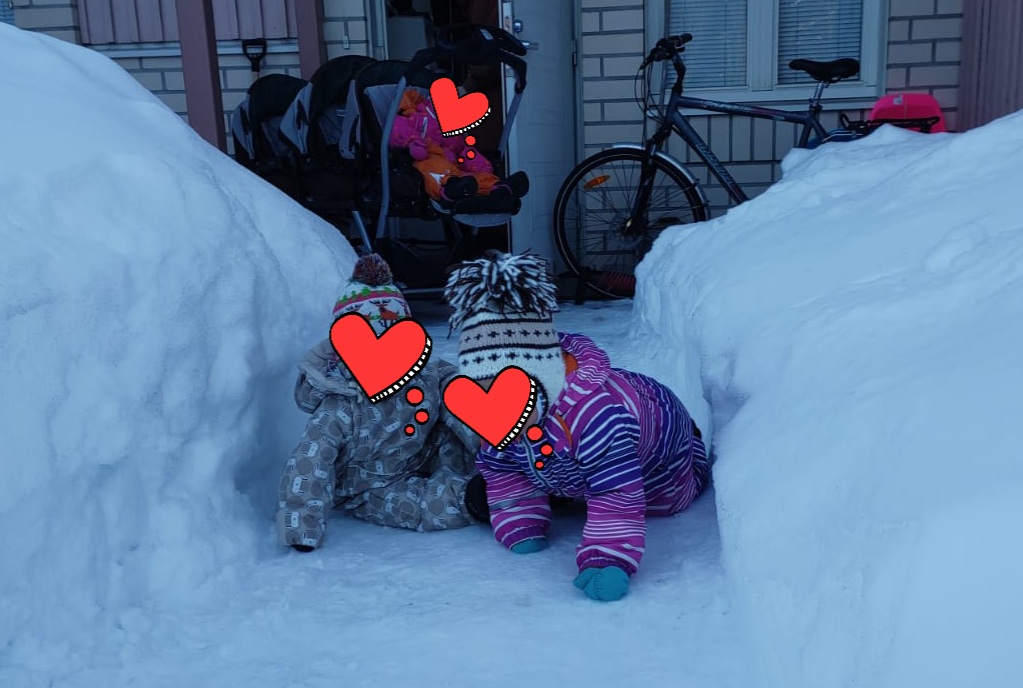 Kolme lasta ulkoilemassa, kasvot peitetty emojein.