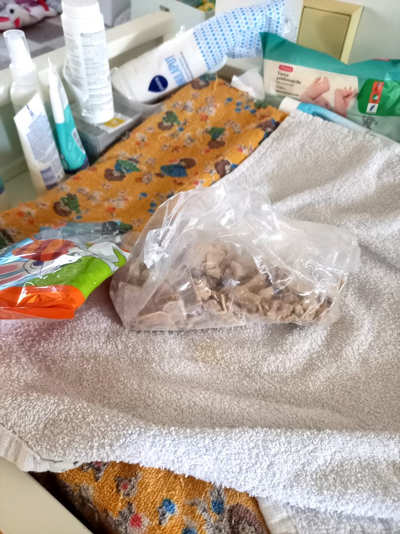 Pussillinen kebablastuja ja tyhjä suklaamunapussi vauvan vaipanvaihtoalustalla.