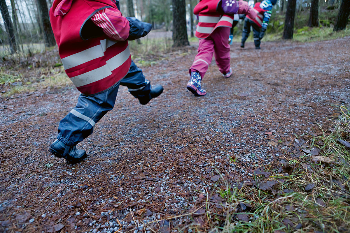Lähikuva lasten jaloista märällä metsäpolulla.