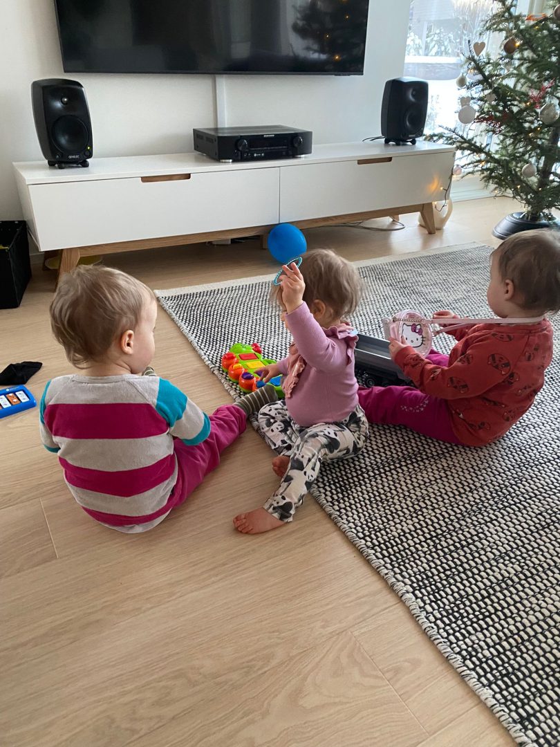Kolme lasta leikkimässä, selin kameraan.