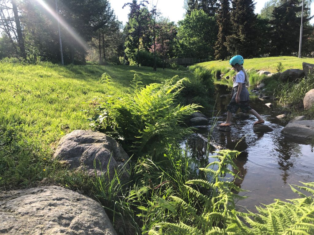 Lapsi ylittää puroa