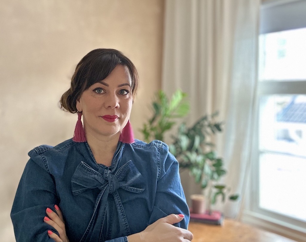 Puolikuva Elisa Miininistä, joka seisoo työhuoneessaan.