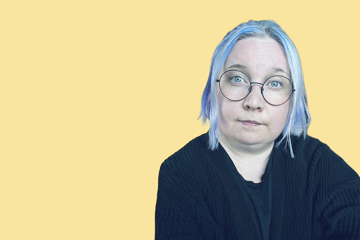 Keltaiselle pohjalle syvätty kuva naisesta, jolla on tumma neule ja siniset olkapäille ulottuvat hiukset sekä silmälasit.