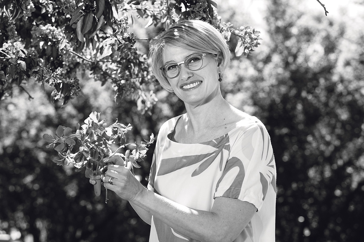 Ulla Siimes ulkona puutarhassa mustavalkoisessa kuvassa.