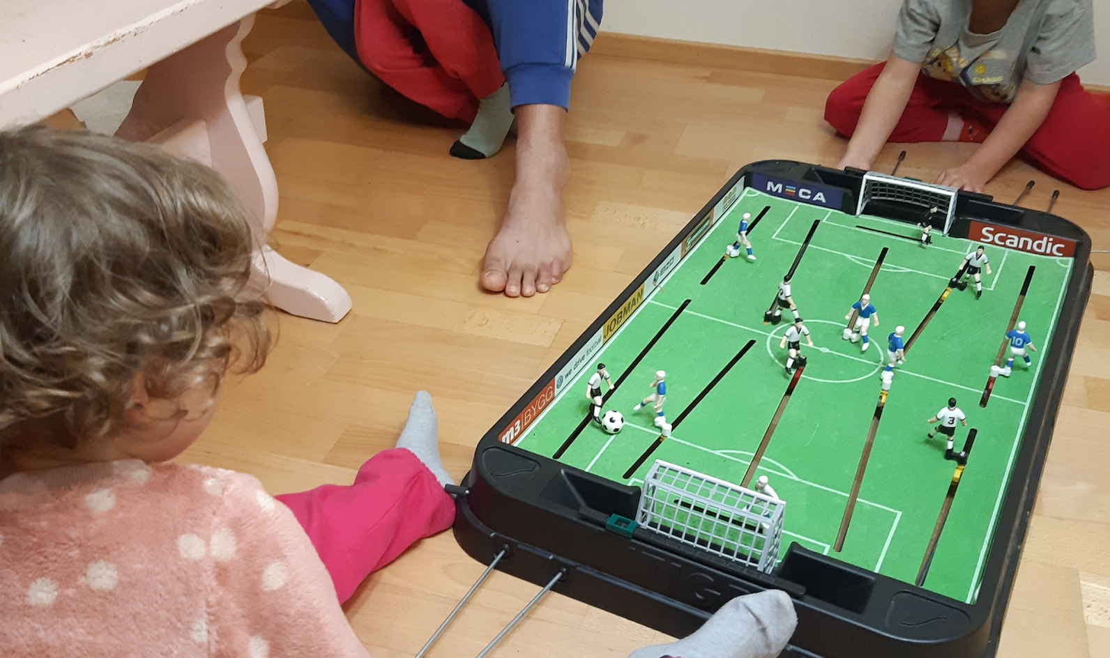 Kaksi lasta pelaa pöytäjalkapalloa.