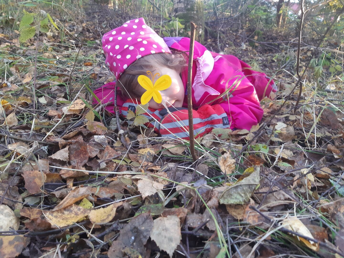 Lapsi makaa lehtikasassa.