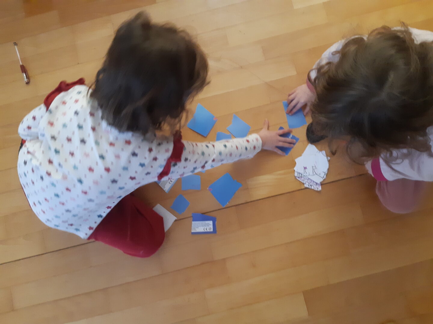 Kaksi lasta pelaa itse tehtyä muistipeliä.