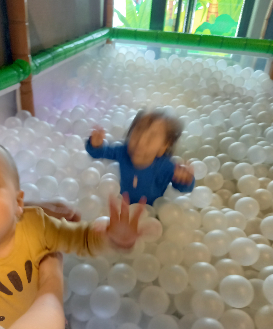 Kaksi lasta pallomeressä. Tärähtänyt kuva.