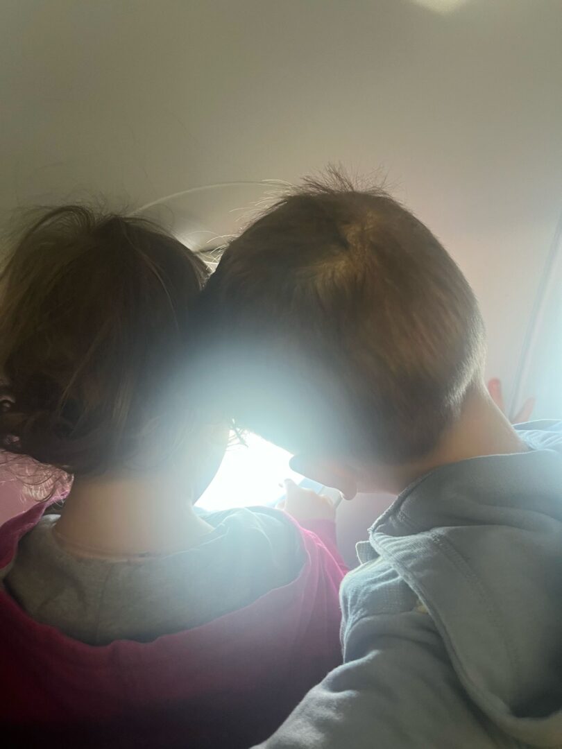 Kaksi lasta katsoo lentokoneen ikkunasta.