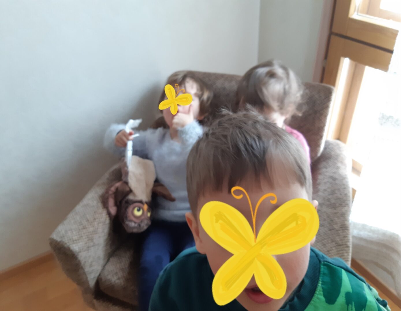 Kaksi lasta nojatuolissa ja yksi edessä.