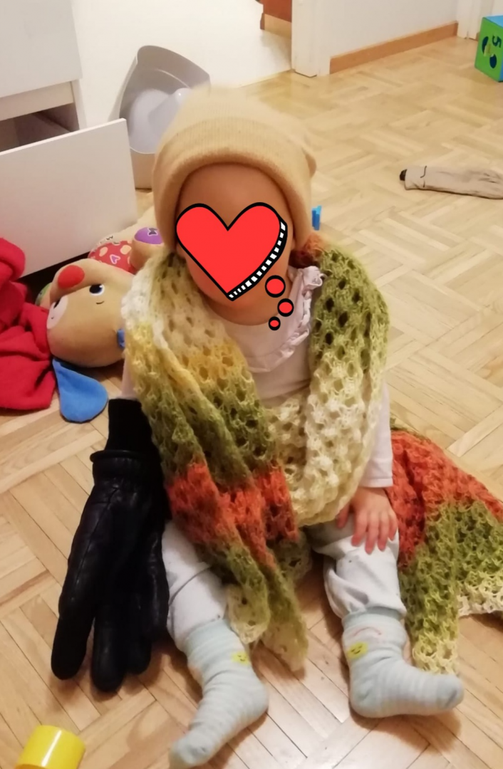 Lapsi aikuisten asusteissa. Kasvot peitetty.