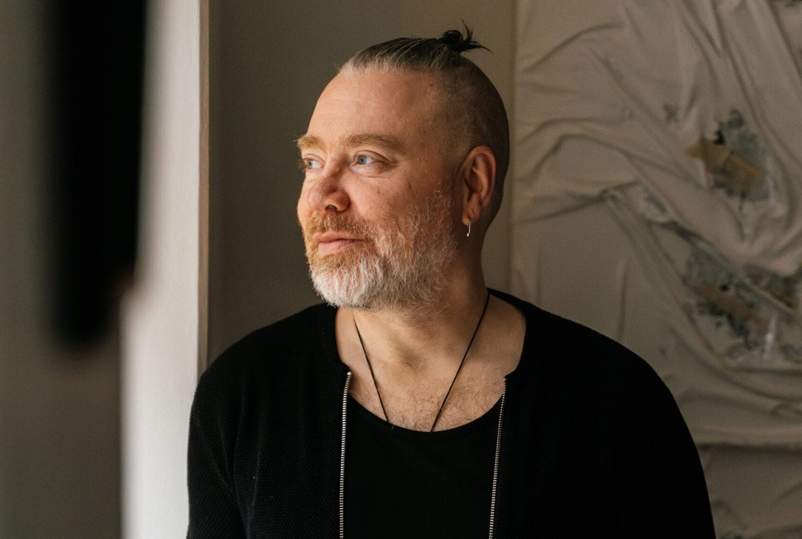 Jukka Vuorio katselee sivuttain kameraan ulos ikkunasta.