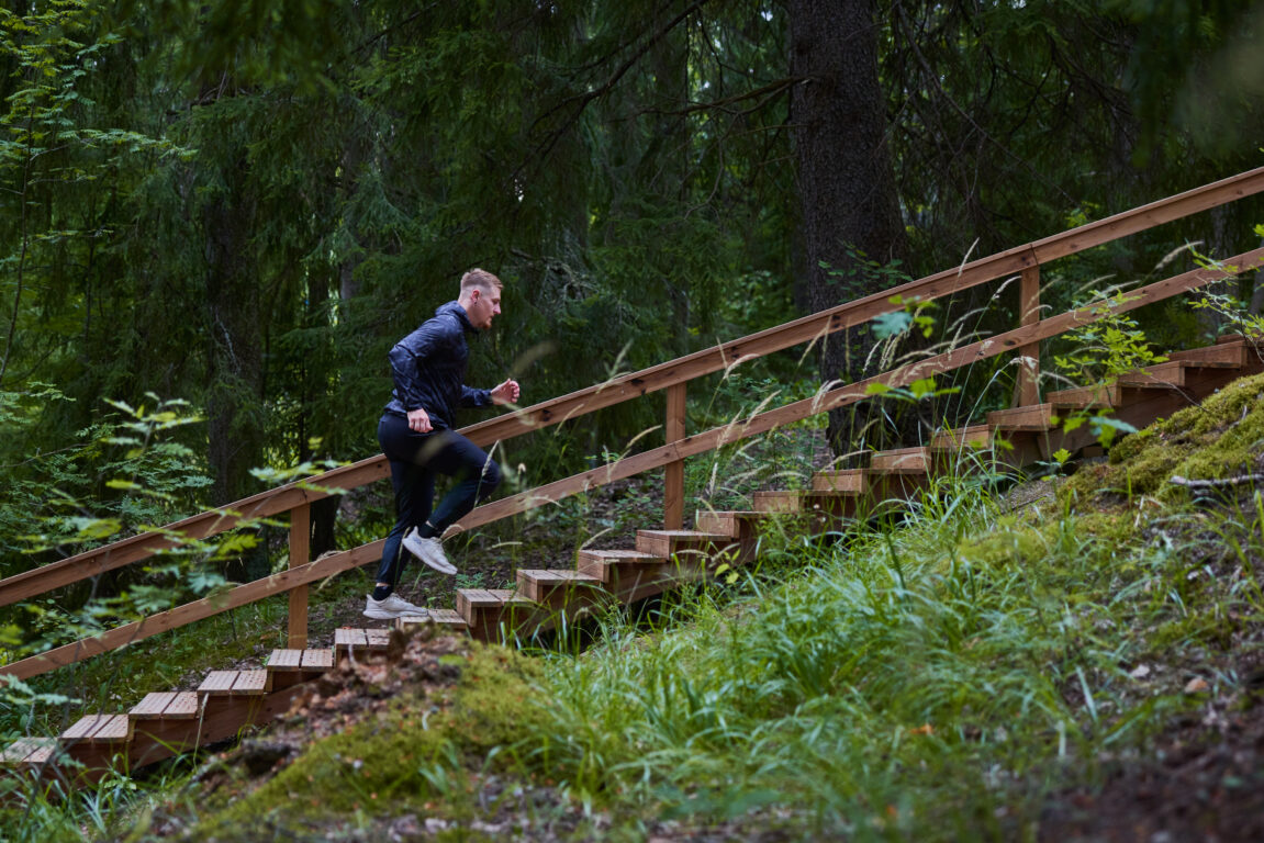 Jouni Kokkonen juoksee kuntoportaita metsässä.