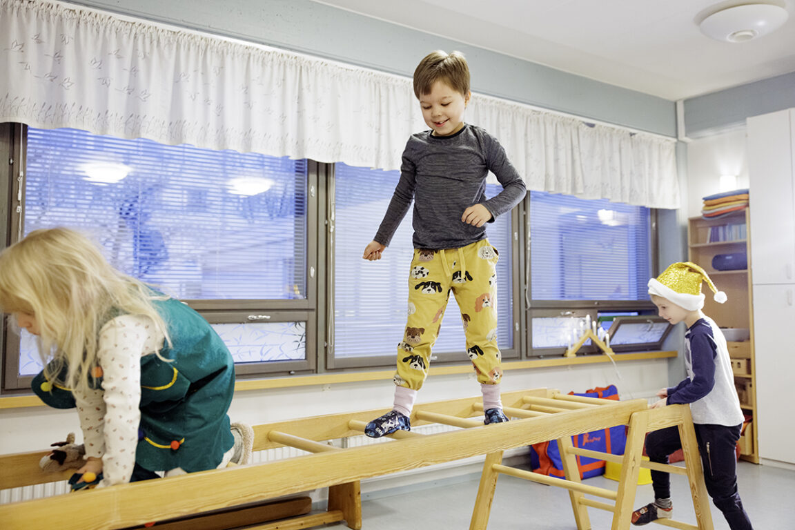 Leikki-ikäinen lapsi kävelee kiipeilytelinettä pitkin. 