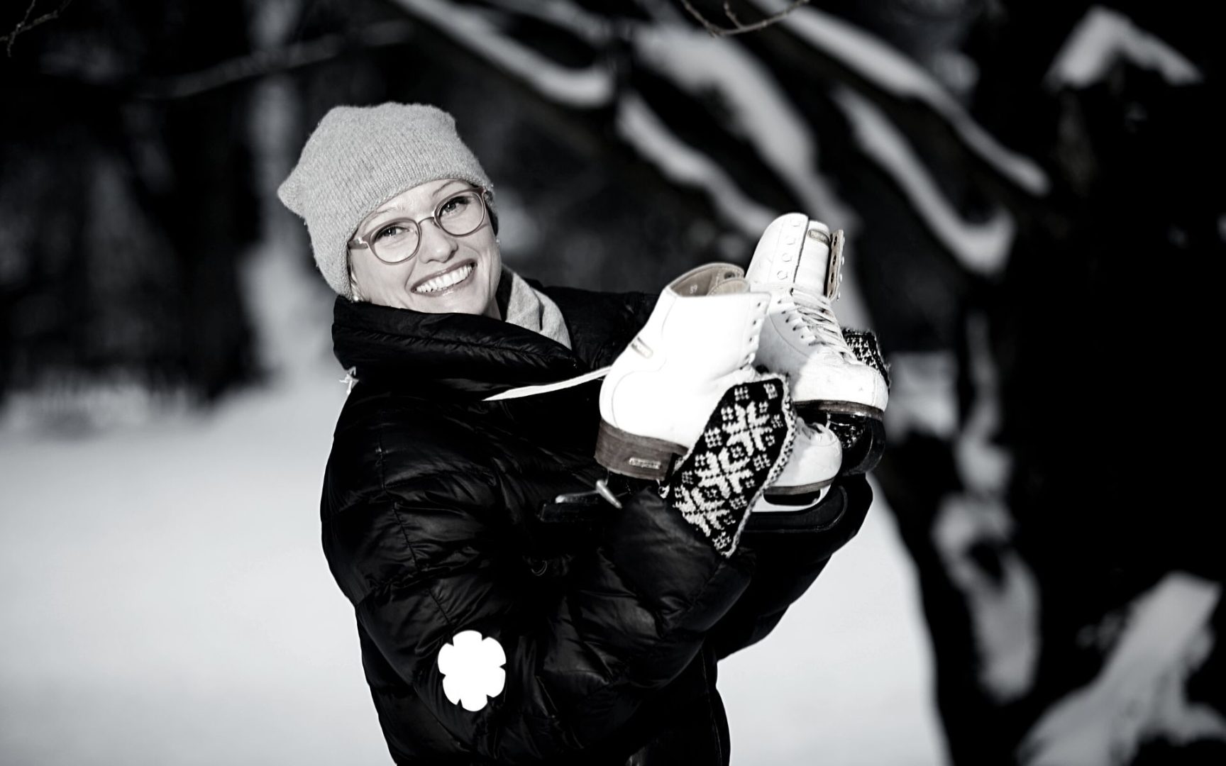 Ulla Siimes katsoo hymyillen kameraan ulkona talvivaatteissa ja pitelee käsissään luistimia.