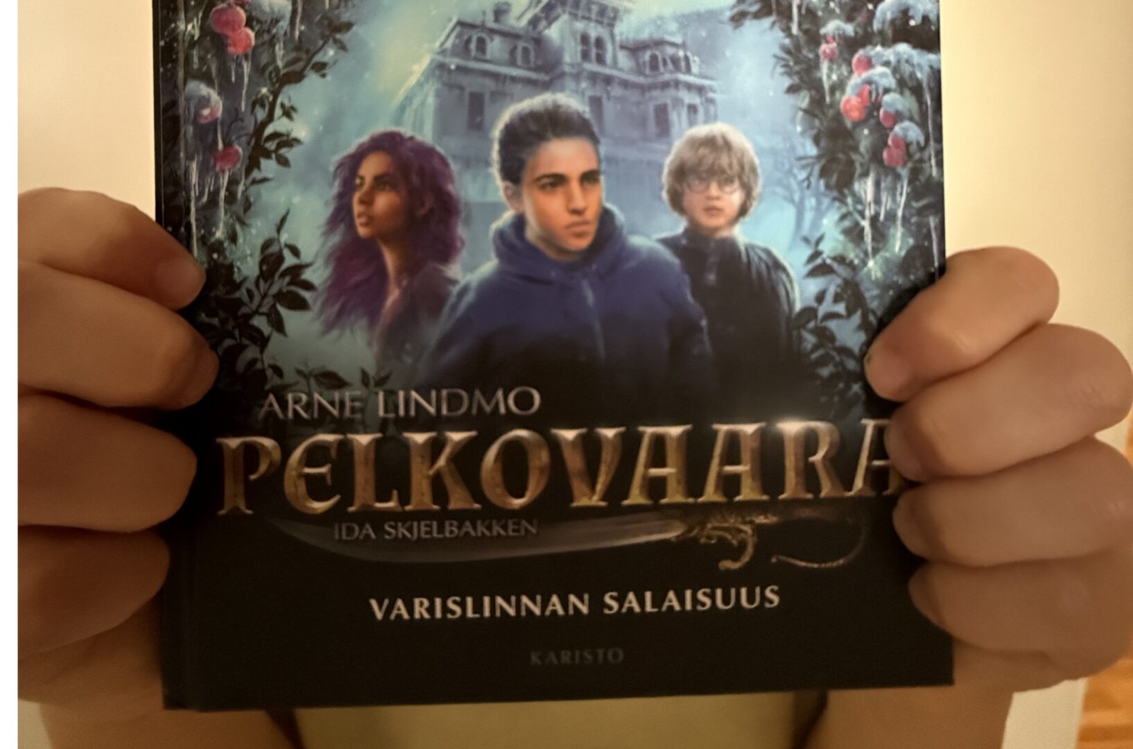 Lähikuva Varislinna-kirjan piirroskannesta, jossa seisoo kolme lasta.